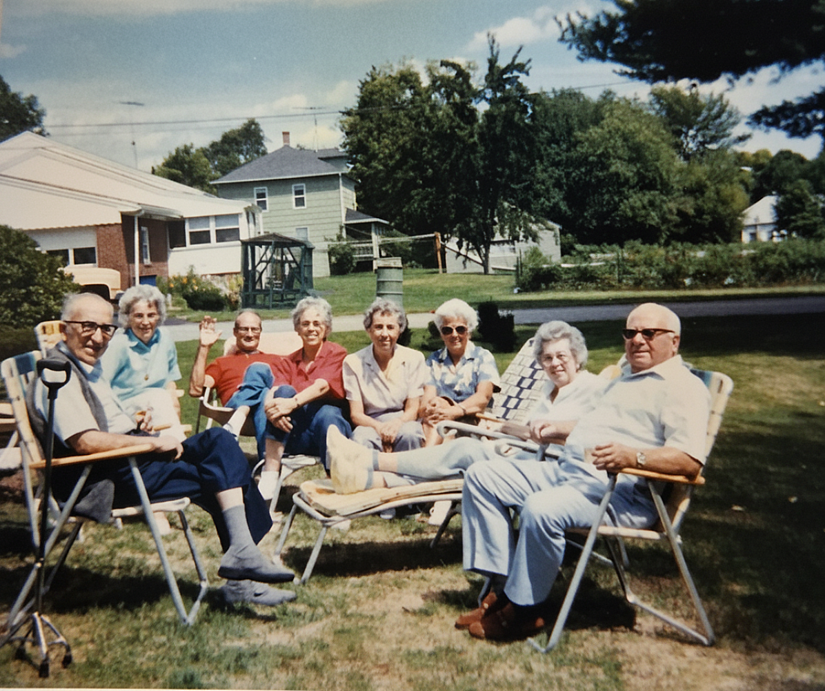 Vintage photo of an extended family gathered together in lawn chairs in the backyard