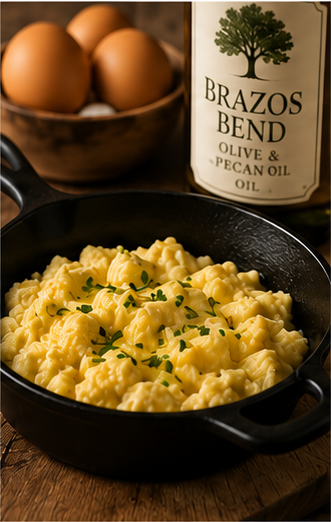 Fluffy scrambled eggs in a cast iron skillet cooked with Brazos Bend oil blend